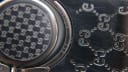 Extreme close-up of the case back engraving and 'GG' monogram on the bracelet, showing the model and serial number clearly.