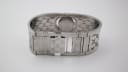 View of the open butterfly clasp on the Gucci T.1.2 bangle bracelet, showing inner 'GG' monogram engraving.