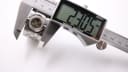 Close-up of a digital caliper measuring the case diameter of the Gucci T.1.2 watch at 23.05mm.