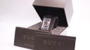 The Gucci T.1.2 watch in its original brown box, alongside original papers.