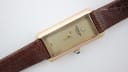 Angled front view of Raymond Weil 310 rectangular gold-tone watch with champagne diamond dial and brown leather strap.