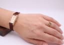 Raymond Weil 310 rectangular watch worn on a female wrist, alongside a gold diamond ring.