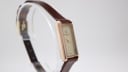 Angled side view of the Raymond Weil 310 watch on a clear stand.