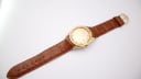 Full length view of the Royce Leadership 1100 watch on its brown crocodile-grain effect leather strap with gold-tone buckle.