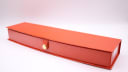 Closed view of the red presentation box, showing its textured finish.