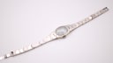 Overhead full view of the Tissot Stylist watch with its integrated steel bracelet laid flat.