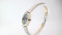 Side view of the Tissot Stylist watch, showing the two-tone case with gold-plated flanks and crown.