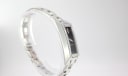 Angled view of the Gucci 110 watch, showcasing the sleek, curved rectangular case and the link bracelet.