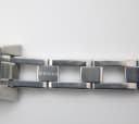 Close-up of the stainless steel bracelet showing the 'GUCCI' engraving on a link.
