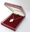 Angled view of the Seiko pendant watch inside its open original red presentation box.