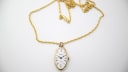 Full view of the gold-tone Seiko pendant watch with its integrated chain on a white background.