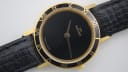 Close-up of the Amara black dial, showing the gold "AMARA" logo, 'SWISS MADE' text, and slender gold hands.