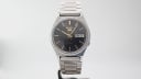 Front view of the Seiko 5 automatic watch on a stand, showcasing its classic design.