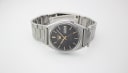 Top-down angled view of the watch, showing the full stainless steel bracelet.
