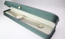The Longines Flagship watch displayed in a green leatherette presentation box with a gold crown emblem.