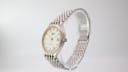 Angled side view of the Longines Flagship watch, highlighting the two-tone case and profile, with the integrated bracelet curving upwards.