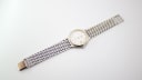 Top-down view of the Longines Flagship watch with its multi-link steel bracelet unclasped and laid flat.