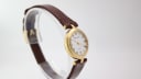 Angled side view of the Solvil et Titus Sonville gold-tone watch on a display stand, showing the strap detail.
