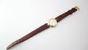 Overhead view of the Solvil et Titus Sonville watch with its brown lizard effect leather strap fully extended, showing the buckle.
