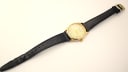 Overhead view of the Rodania 18711 watch with its black leather strap fully extended and a gold-tone buckle.