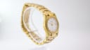 Oblique side view of the Certina DS gold tone watch on a clear stand, showing the case and bracelet.