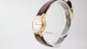 Angled side view of the Tissot Seastar, highlighting the gold-tone case and crown on a display stand.