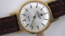 Close-up of the silver sunburst dial of the Tissot Seastar, showing gold-tone baton indices and Tissot logo.