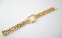 Full length top-down view of the Caravelle N.1 watch and its textured gold tone metal bracelet.