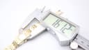 Digital caliper measuring the case width of the Seiko watch at 16.12 mm.