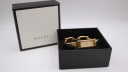 The Gucci 1500L watch positioned next to its original black Gucci box.