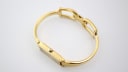 Side view of the Gucci 1500L watch with its integrated gold tone bracelet and clasp.