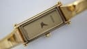 Close-up of the champagne rectangular dial with 'GUCCI' logo and 'SWISS MADE' text, showing the fine details.