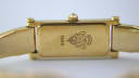 Rear view of the gold tone case back with '1500' and Gucci crest, showcasing the integrated bracelet design.
