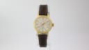 Front view of the Slava gold-tone ladies watch with cream sunburst dial and brown leather strap.