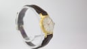 Three-quarter view of the Slava vintage watch on a clear display stand, highlighting the case profile.