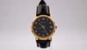 Side angled view of the gold-tone Ingersoll watch on a display stand, showing the polished case.