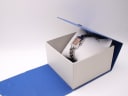 The Tissot L730K watch resting inside its original blue and white Tissot presentation box.