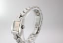 Angled side view of the Tissot L730K watch, showing the crown and polished stainless steel case and bracelet.