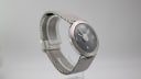 Angled side view of the watch, highlighting the mesh bracelet's curvature.