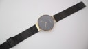 Overhead view of the Bering watch with the black mesh bracelet laid flat, showing the adjustable clasp.
