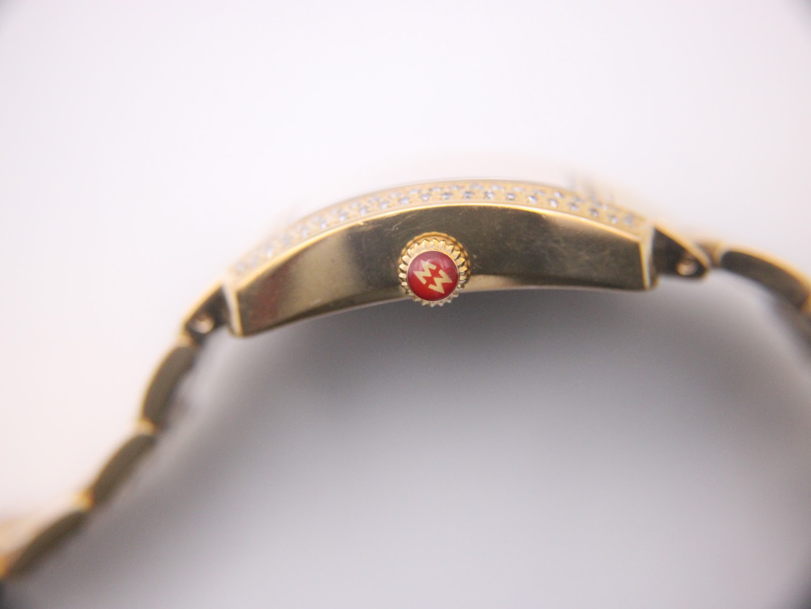 Gold-tone Michele bracelet wrapped around a wrist sizing gauge, showing a wrist circumference of approximately 14.5 cm.