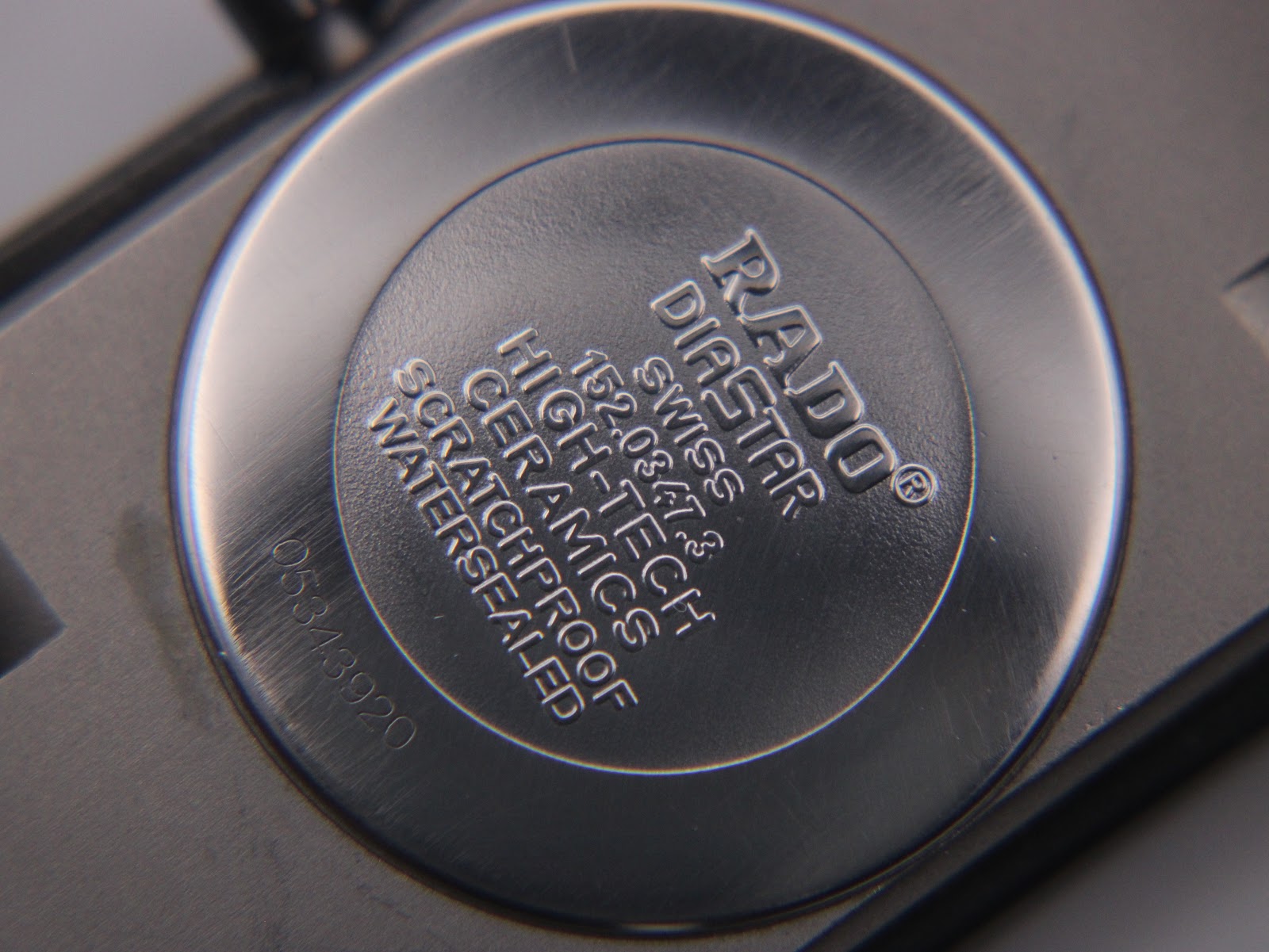 Close-up of the Rado Diastar case back and adjacent ceramic links, showing the serial number 0543920.
