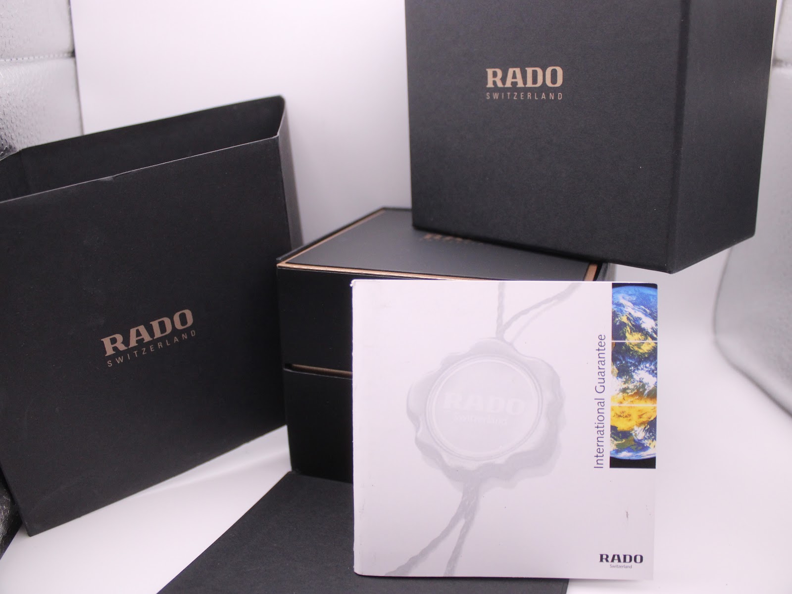 Original RADO watch packaging, including the outer box, inner box, and the International Guarantee booklet with a globe motif.