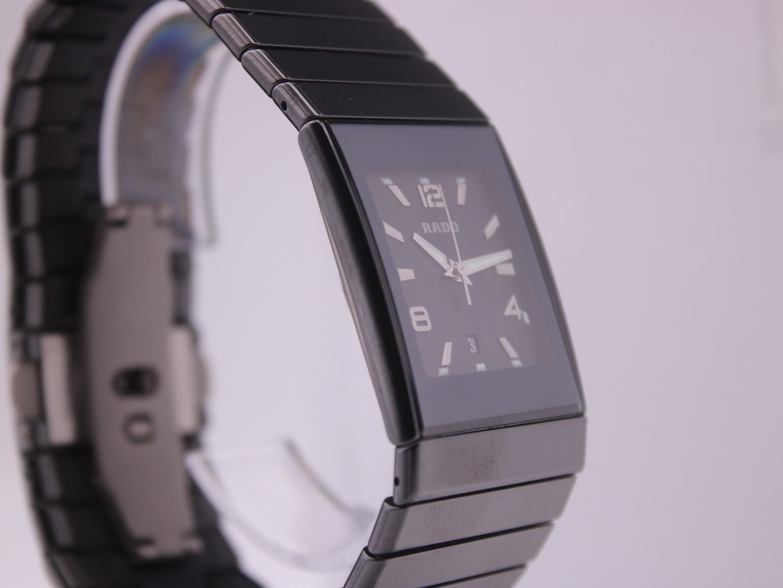 Angled view of the Rado Diastar watch on a display stand, showcasing the rectangular case and the seamless black ceramic bracelet.