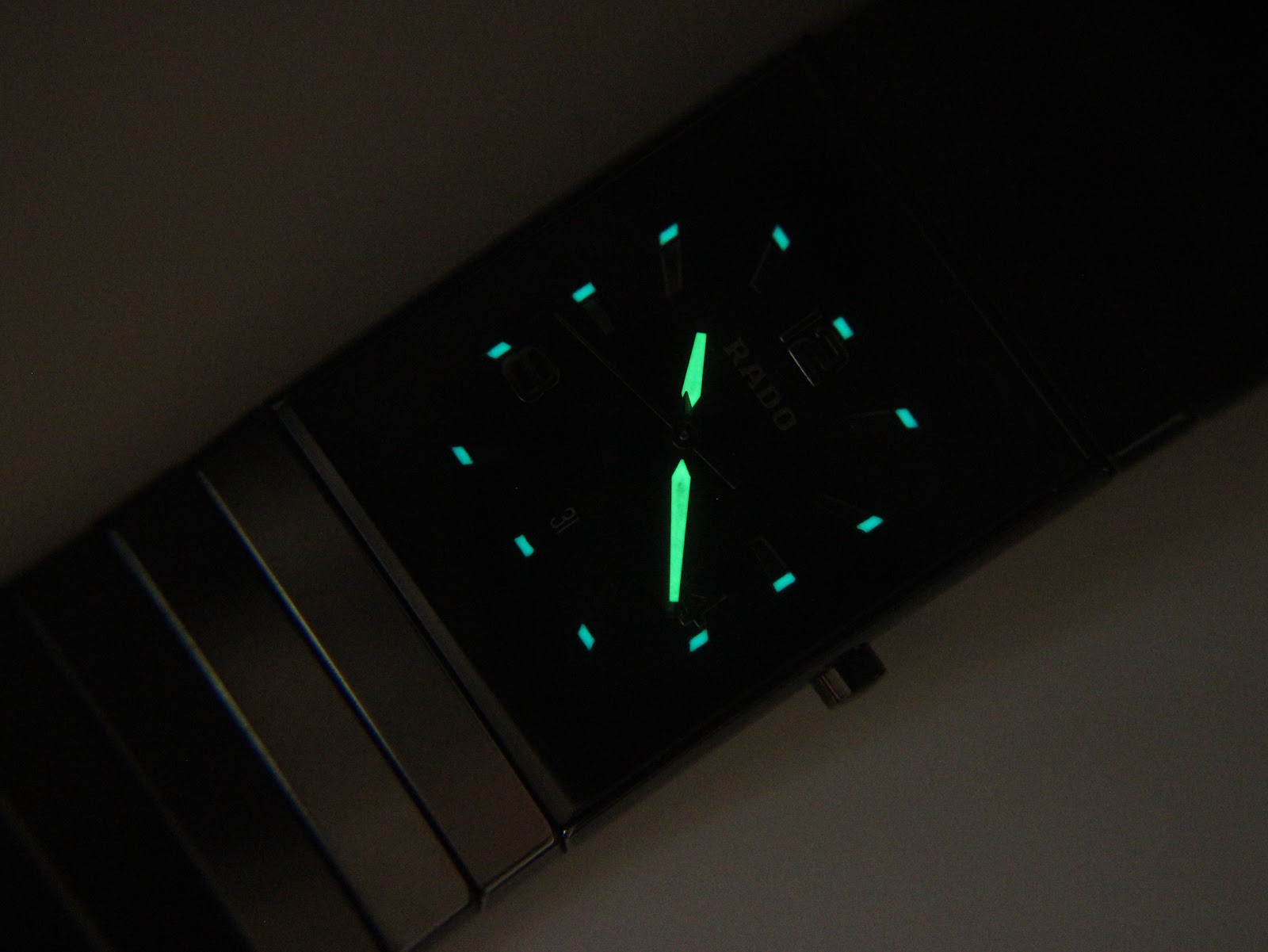 Lume shot of the Rado Diastar dial, showing the bright green glow of the luminous hands and hour markers in the dark.