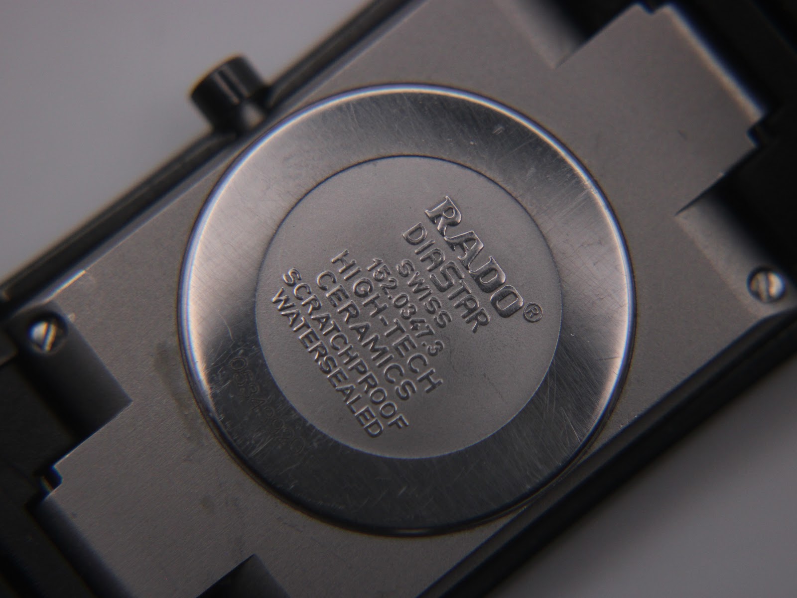 Close-up of the watch case back, engraved with "RADO DIASTAR SWISS HIGH-TECH CERAMICS SCRATCHPROOF WATERSEALED" and model number 152.0347.3.