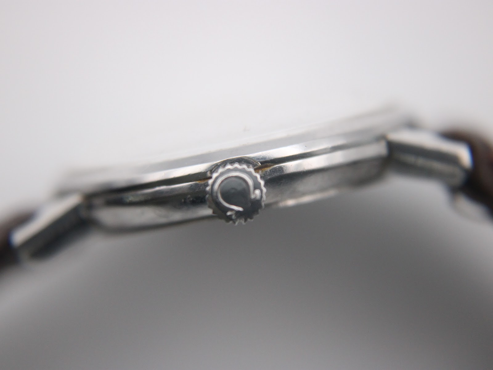 Close-up of the watch crown, featuring the embossed Omega logo.