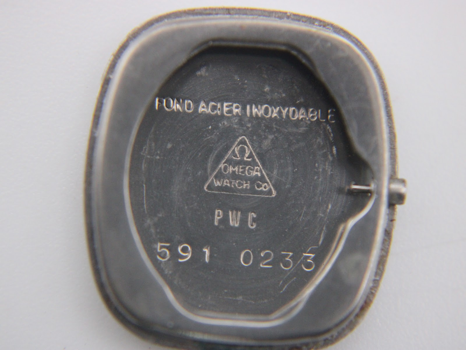 Inside of the Omega De Ville case back, showing "Fond Acier Inoxydable" and model number 591 0233.