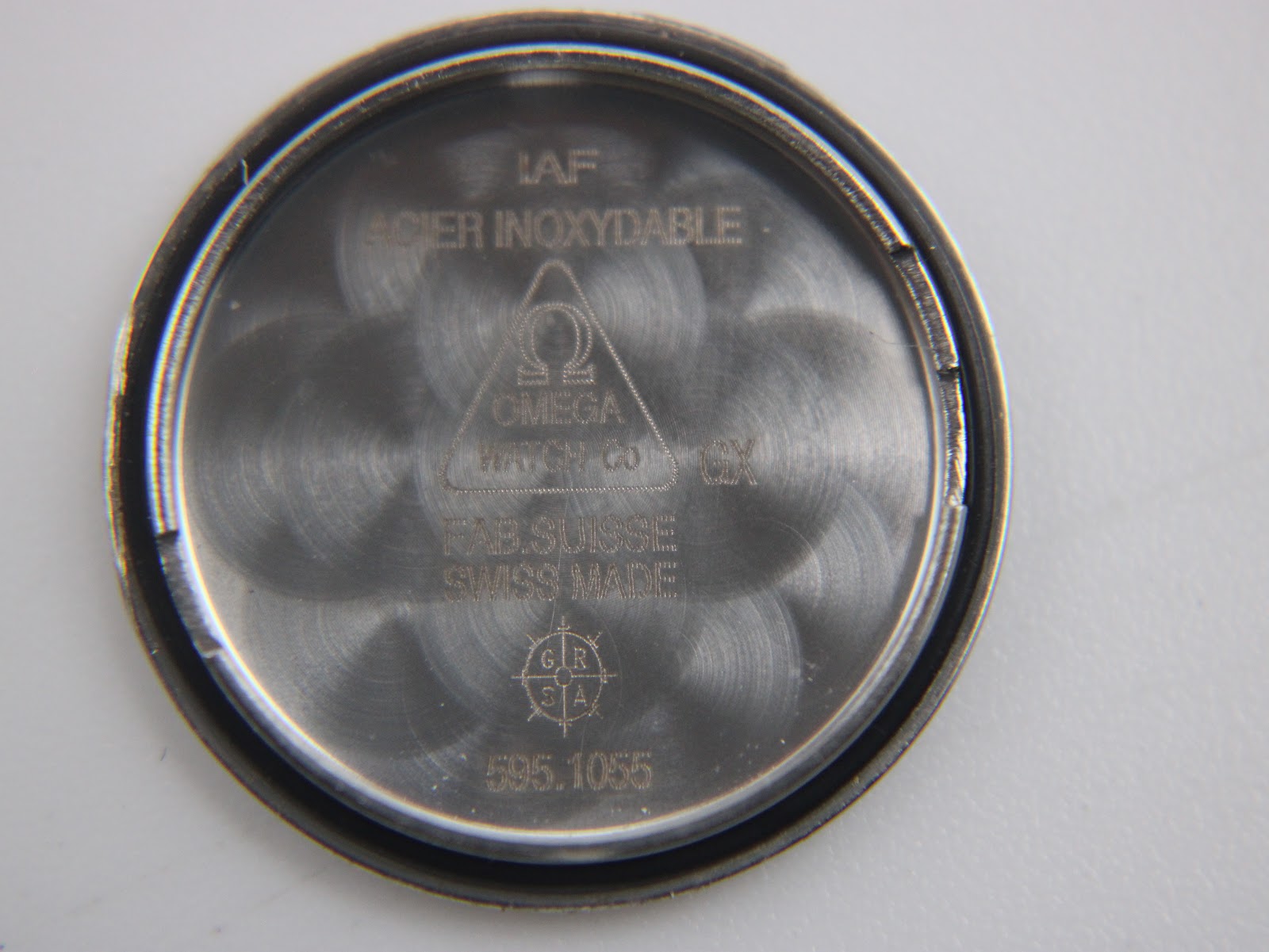 Interior of the Omega case back, engraved with "ACIER INOXYDABLE", "FAB. SUISSE SWISS MADE", and "595.1055".