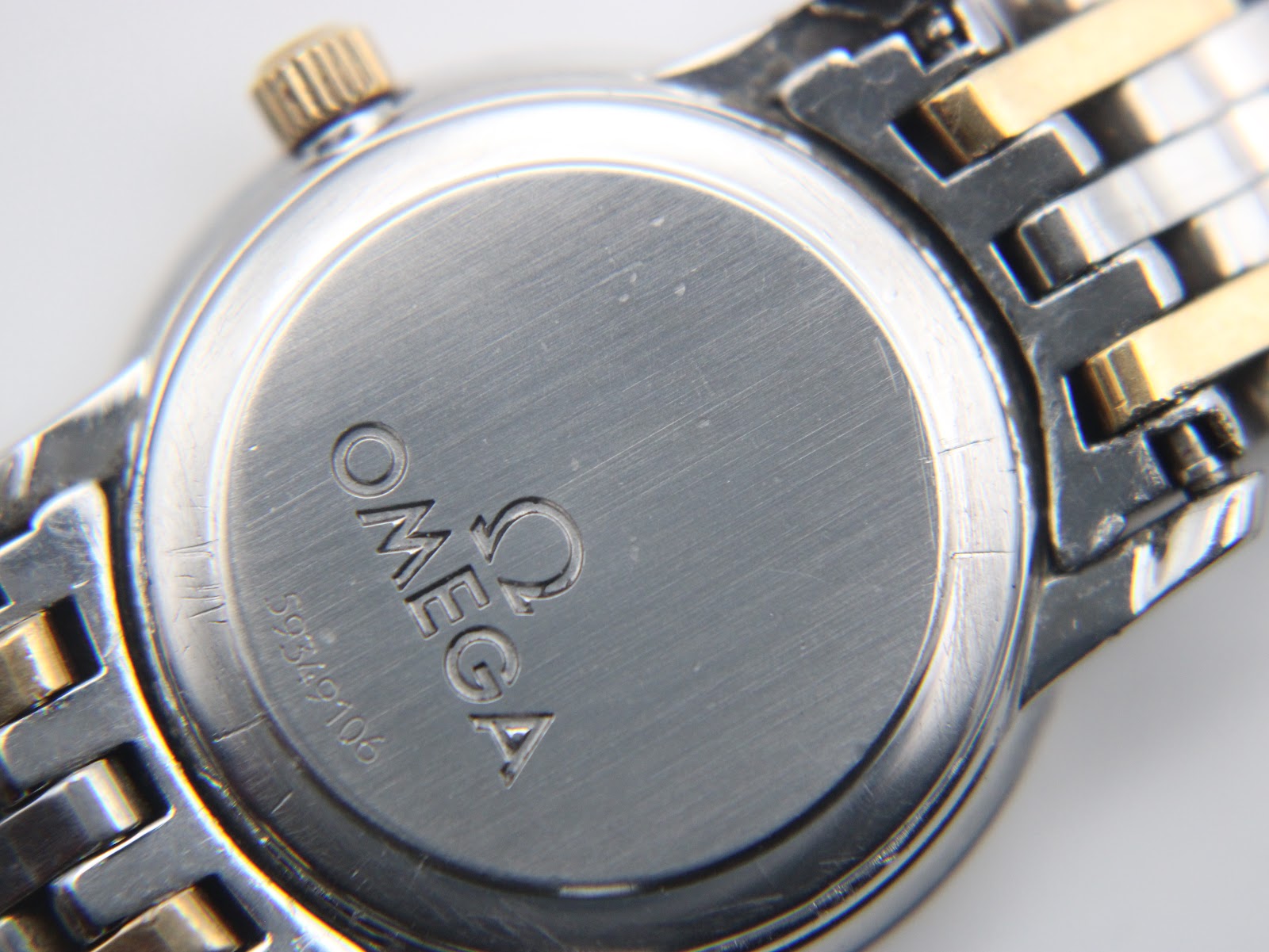 Close-up of the Omega case back with clear view of the serial number 59349106 and Omega logo.